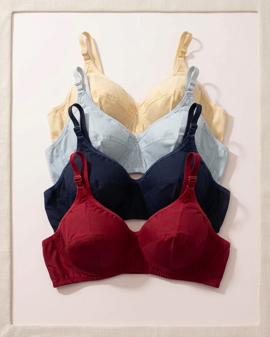 Three wireless underwire bras in different colors are stacked and displayed flat against a light beige textured background. The top bra is a pale yellow, the middle is a light blue, and the bottom is a deep burgundy red.