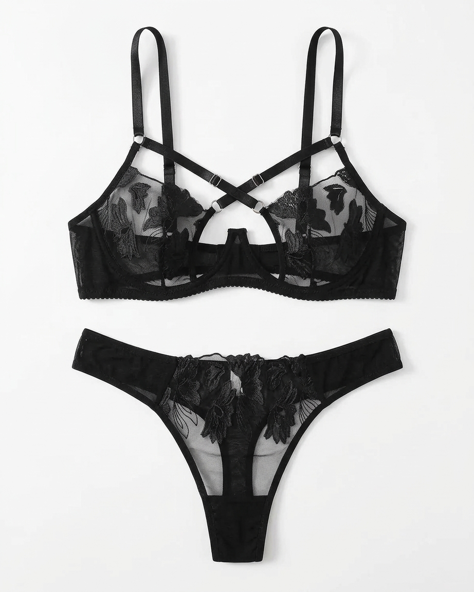 Black sheer lace lingerie set with floral embroidery, featuring a strappy underwire bra and a matching thong, displayed flat against a white background.